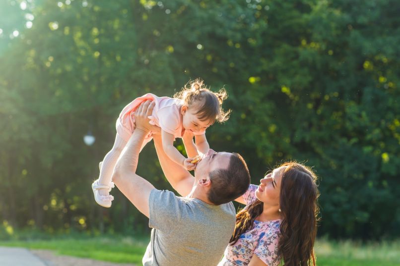 Junge Familie - Vater hebt seine Tochter in die Luft